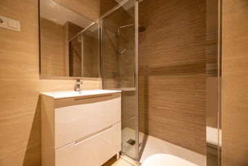 Simple bathroom with walk-in shower, wall-hung frameless mirror, sliding glass door shower stall...