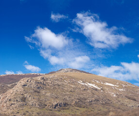 mountain ridge on blue cloudy sky background