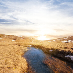 small brook flow among prairie at the sunset