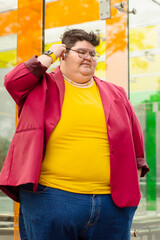 Portrait of a chubby woman using earphones n the street