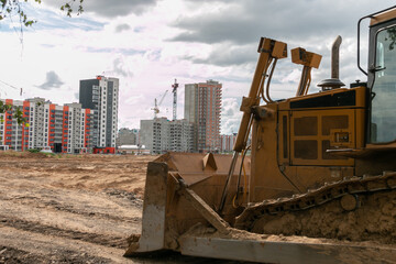 Crawler bulldozer clears the ground with a metal shield. Road construction works. Landscaping.