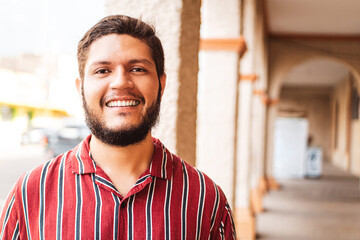 Obraz premium closeup portrait of a young latin american man smiling looking at camera
