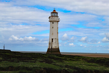 Fototapeta na wymiar A landscape shot of the lighthouse at New Brighton Beach. The tower is approximately 100 metres tall and was used to guide ships for centuries before finally being decommissioned.