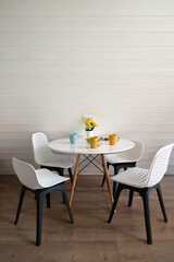Dining area in the living room. One white round table and three white chairs