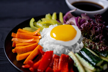 Close-up of Korean dish, with variety of appetizers with vegetables and eggs. Diet. bibimbap. Top view. Round plate.