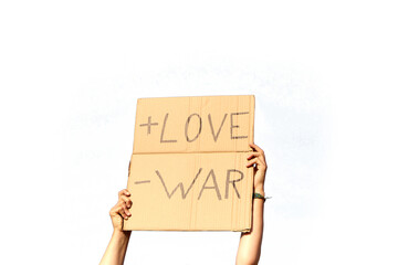 A Cardboard Signs saying More Love, Less War held by two hands on a white background