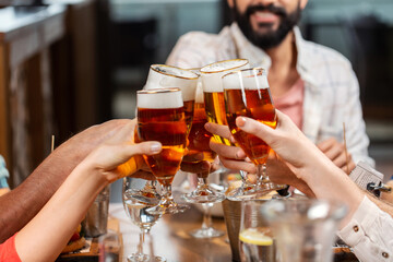 leisure, people and celebration concept - close up of happy friends having dinner and drinking beer at restaurant or pub