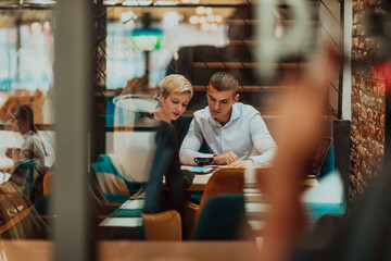 Happy businesspeople smiling cheerfully during a meeting in a coffee shop. Group of successful business professionals working as a team in a multicultural workplace.