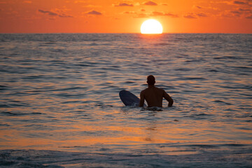 Silhouette of Surfer waiting on the line up for a wave at sunrise or sunset