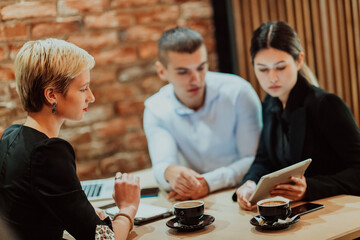 Happy businesspeople smiling cheerfully during a meeting in a coffee shop. Group of successful business professionals working as a team in a multicultural workplace.
