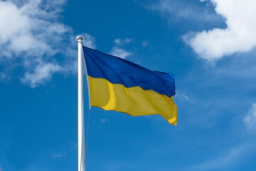Flag of Ukraine on white sky background. National symbol of freedom and independence. Ukrainian flag waving in wind.