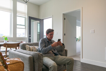 Young man using phone at home in a modern apartment