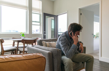 Young man talking on cell phone at home in a stylish apartment