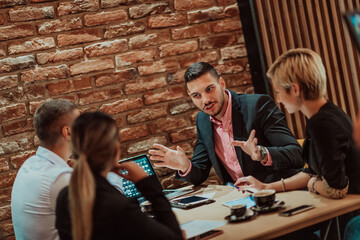 Happy businesspeople smiling cheerfully during a meeting in a coffee shop. Group of successful business professionals working as a team in a multicultural workplace.