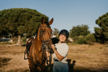 portrait of a smiling 17-year-old girl holding her horse by its head