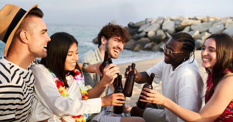 Sunset on the Boardwalk with happy friends at the beach cheering with Beer - Focus on the boy with the hat on the left