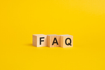 wooden blocks with word FAQ on yellow paper. frequently asked question concept