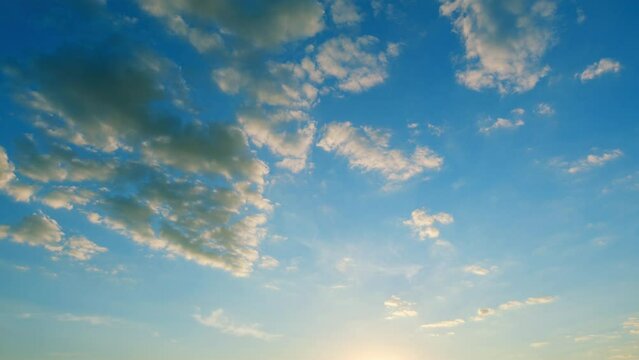 Soft white clouds moving on blue sky background. Tropical summer or spring sunlight. Sunset Time lapse.