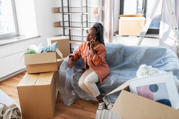 moving, people and real estate concept - angry woman with boxes calling on smartphone at new home
