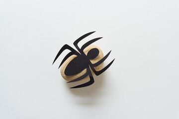 paper spider isolated on a yellow rock and white space
