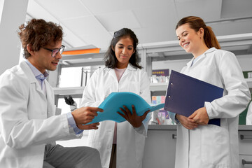 science research, work and people concept - international group of happy scientists with folder...