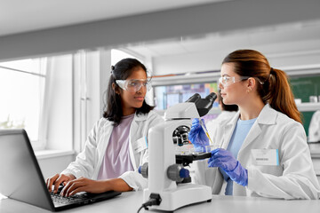 science research, work and people concept - international female scientists with microscope and...