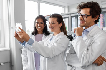 science research, gene technology and people concept - international group of happy scientists with petri dish working in laboratory