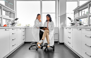 science research, work and people concept - happy international female scientists with tablet pc...