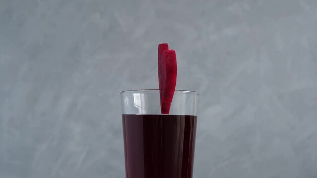 Healthy drink with beetroot juice. Glass of red beverage decorated slice of beet heart shaped. Salgam, Fermented homemade drinks. Rotation motion. Sale Banner, clip for street cafe or social media.