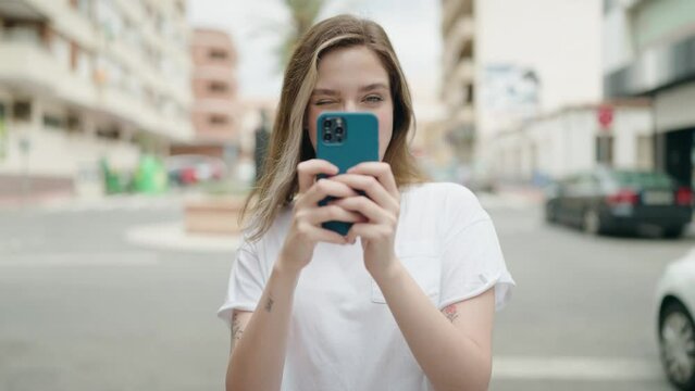 Young woman smiling confident making photo by smartphone at street