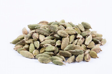 Closeup top view of dried green Elettaria cardamomum fruits with seeds, cardamom spice scattered on...