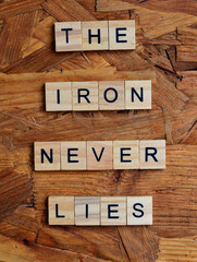 the iron never lies text on wooden square, inspiration quotes