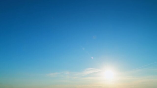 Beautiful sunny cloudless clear sky with bright sun shining with sunlight rays. Dynamic light rays, lens flare effects. Time lapse.