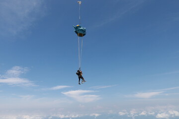 Fototapeta na wymiar Skydiving. Tandem jump in the cloudy sky.