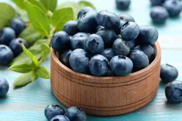 Tasty fresh blueberries on light blue table, closeup