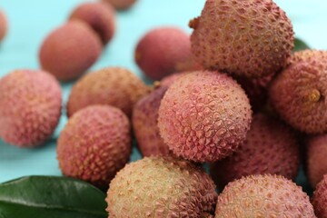 Fresh ripe lychee fruits on light blue table, closeup