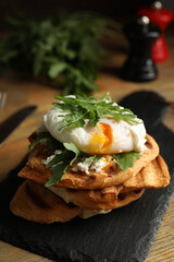 Delicious sandwich with arugula and egg on wooden table, closeup