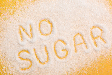 Phrase No Sugar made of granules on yellow background, flat lay