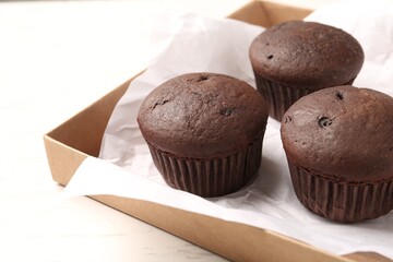 Delicious fresh chocolate cupcakes on white table, closeup