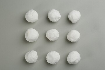 Round snowballs on grey background, flat lay