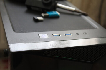 A USB memory stick, screwdriver and an action camera on a computer case. Black concept