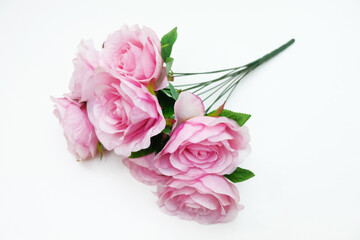 Bouquet of artificial pink roses on white background