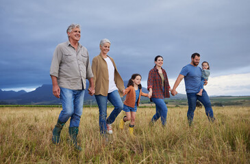 Big happy family walking on field, meadow and countryside in nature to relax, bond and holding...