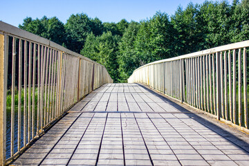Old wooden bridge. Bridge over river. Yellow bridge in the summer in the park, forest.