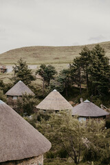 African huts overlooking valley in lesotho, africa