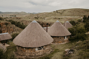African huts overlooking valley in lesotho, africa