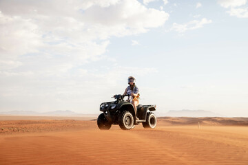 female traveler riding quad bike through desert of namibia - obrazy, fototapety, plakaty