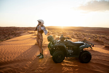 female traveler putting on helmet before riding quad bike through desert of namibia