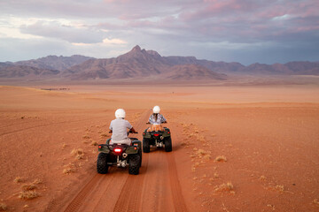 tourists on quad bikes riding through the desert in namibia