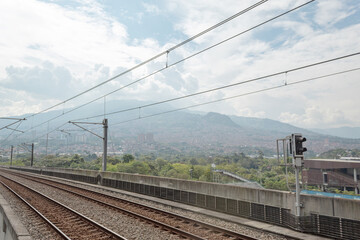 Metro rails with a city and mountains in the background. Medellin Colombia.